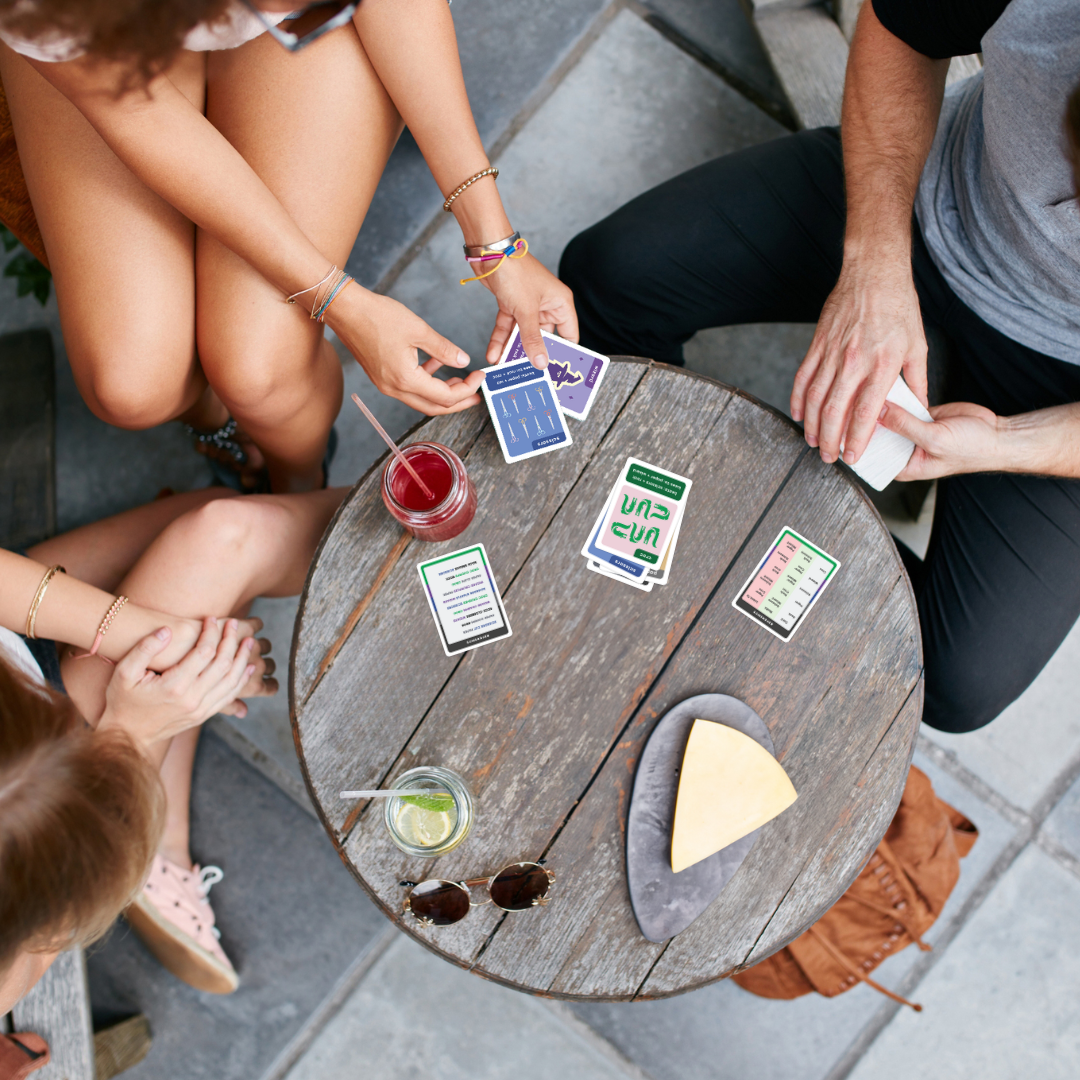 RPSWC featured as a fun and portable by young adults playing the game on a café table with food, drinks and sunglasses on it.